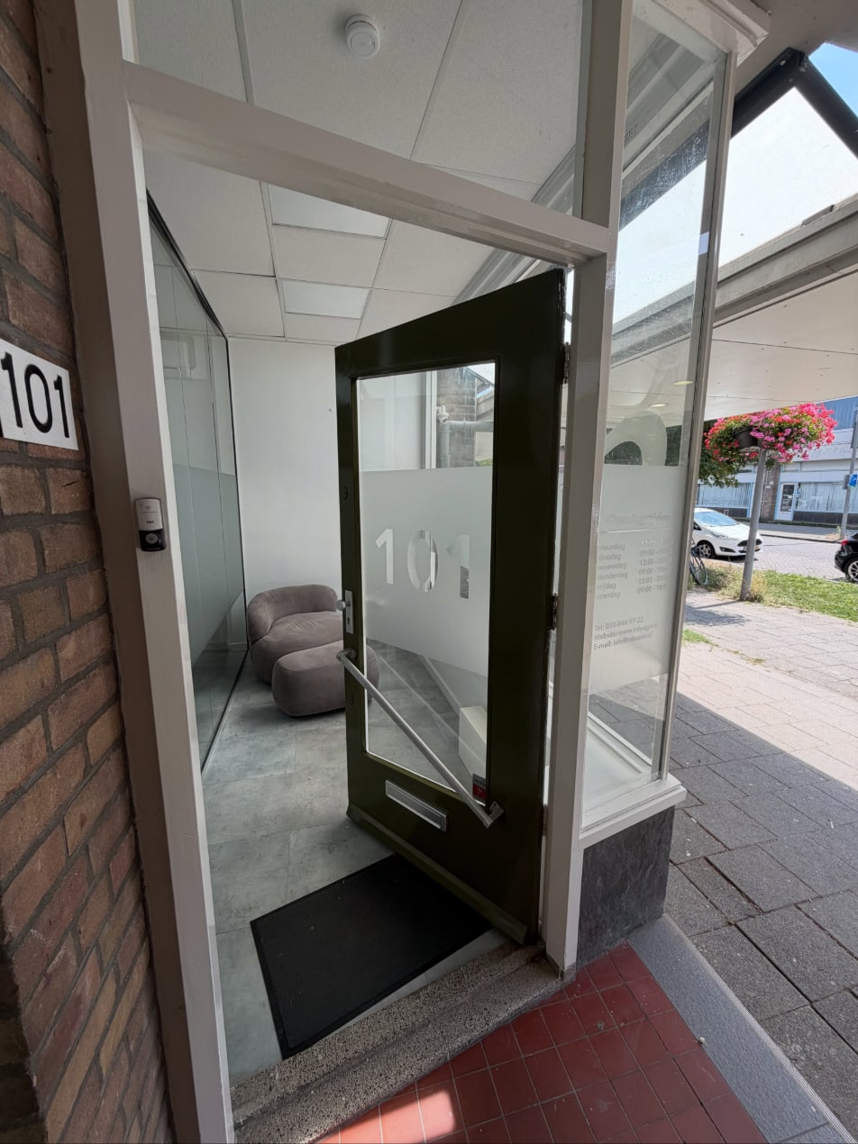 Donkergroen geschilderde voordeur met glas in een wit geschilderd kozijn