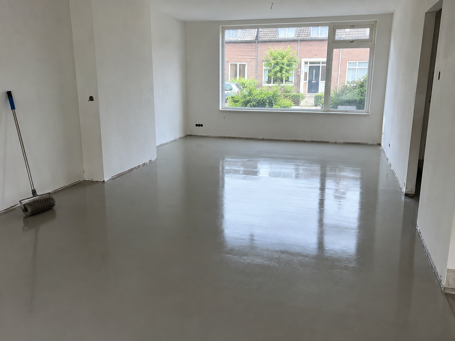 Lege kamer met een vers geëgaliseerde, gladde grijze vloer